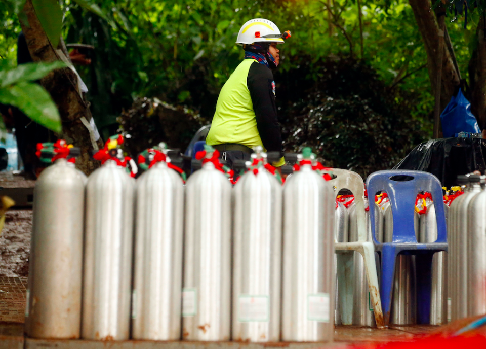 A Thai rescuer prepares oxygen tanks for diving (Picture: PA)