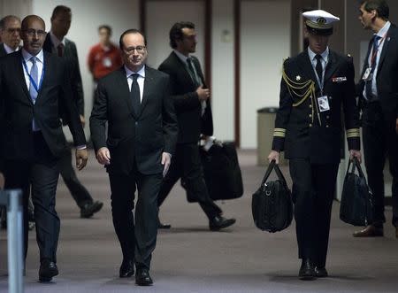 French President Francois Hollande (foreground on L) arrives in a press room to give a statement at the European Council headquarters in Brussels, June 26, 2015. REUTERS/Yves Herman