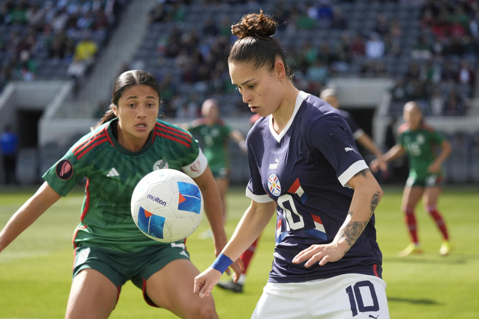 Paraguay forward Jessica Martinez, right, controls the ball in front of Mexico defender Rebeca Bernal during the first half of a CONCACAF Gold Cup women's soccer tournament quarterfinal, Sunday, March 3, 2024, in Los Angeles. (AP Photo/Marcio Jose Sanchez)