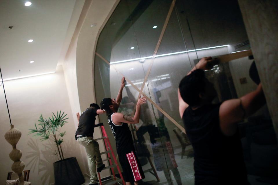 Workers of the Motto by Hilton Hotel put tape on windows, ahead of the arrival of Hurricane Beryl, in Tulum, Mexico, July 5, 2024 (REUTERS)