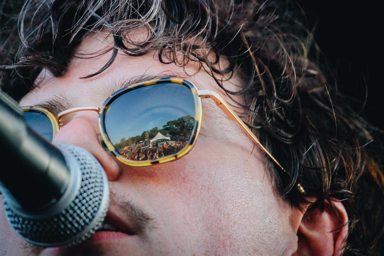 The crowd during the third day of the 2022 Roots N Blues festival is reflected through Houndmouth frontman Matt Myers' sunglasses.