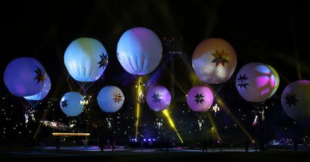 Performers dangling from balloons rise into the air during the Opening Ceremonies of the Copa America 2015 soccer tournament at the National Stadium in Santiago, Chile June 11, 2015. REUTERS/Henry Romero