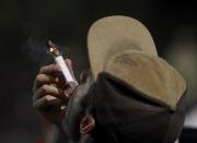 A man smokes marijuana as marijuana enthusiasts gather after midnight to celebrate the legalization of recreational use of marijuana in Portland, Oregon July 1, 2015. Smoking and growing small amounts of marijuana became legal in Oregon on Wednesday, as a growing legalization movement spread down the United States' west coast. A law allowing recreational use, backed by voters in November, came into effect at midnight, opening the way for marijuana to be sold in shops by next year - though some lawmakers say they will still try to block retail outlets. REUTERS/Steve Dipaola