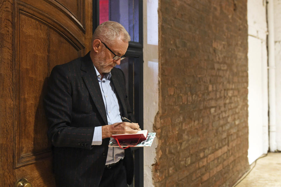 Britain's opposition Labour Party leader Jeremy Corbyn prepares his speech before a rally while on the General Election campaign trail in Birmingham, England, Thursday Dec. 5, 2019. Corbyn is wearing a jacket bearing the party slogan "for the many not the few". Britain's Brexit is one of the main issues for political parties and for voters, as the UK prepares to go to the polls in a General Election on Dec. 12. (Joe Giddens/PA via AP)