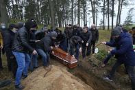 FILE-A local Muslim community buried a Yemeni migrant Mustafa Mohammed Murshed Al-Raimi, in Bohoniki, Poland, Sunday, Nov. 21, 2021. The person is one of about a dozen people from the Middle East and elsewhere who have died in a area of forests and bogs along the Poland-Belarus border amid a standoff involving migrants between the two countries. A year after migrants started crossing into the European Union from Belarus to Poland, Polish authorities are planning to announce Thursday that a 5.5-meter-tall steel wall along its border to the north with Belarus is set to be completed. (AP Photo/Czarek Sokolowski)