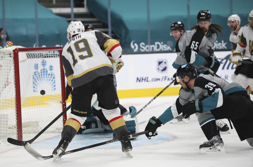 Vegas Golden Knights right wing Reilly Smith (19) scores a goal as San Jose Sharks center Logan Couture (39) defends during the first period of an NHL hockey game in San Jose, Calif., Friday, March 5, 2021. (AP Photo/Josie Lepe)