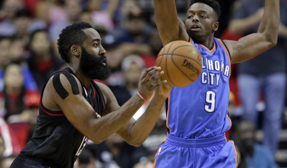 Houston Rockets' James Harden passes under pressure from Oklahoma City Thunder's Jerami Grant (9) in the first quarter of an NBA basketball game in Houston, Thursday, Jan. 5, 2017. (AP Photo/Michael Wyke)