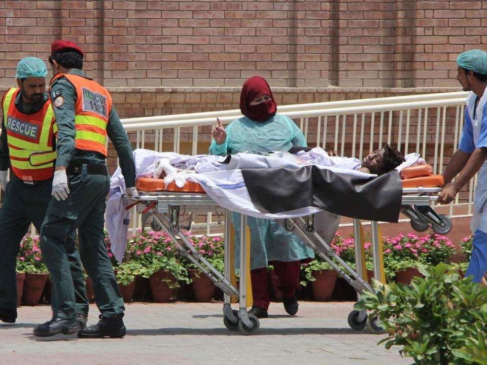 Pakistani rescue workers and paramedics bring a burns victim to a hospital in Multan (Mansoor Abbas/AFP/Getty Images)