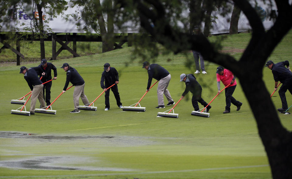 Course workers squeegee the 18th fairway following a weather delay during the final round of the AT&T Byron Nelson golf tournament in McKinney, Texas, Sunday, May 16, 2021. (AP Photo/Ray Carlin)