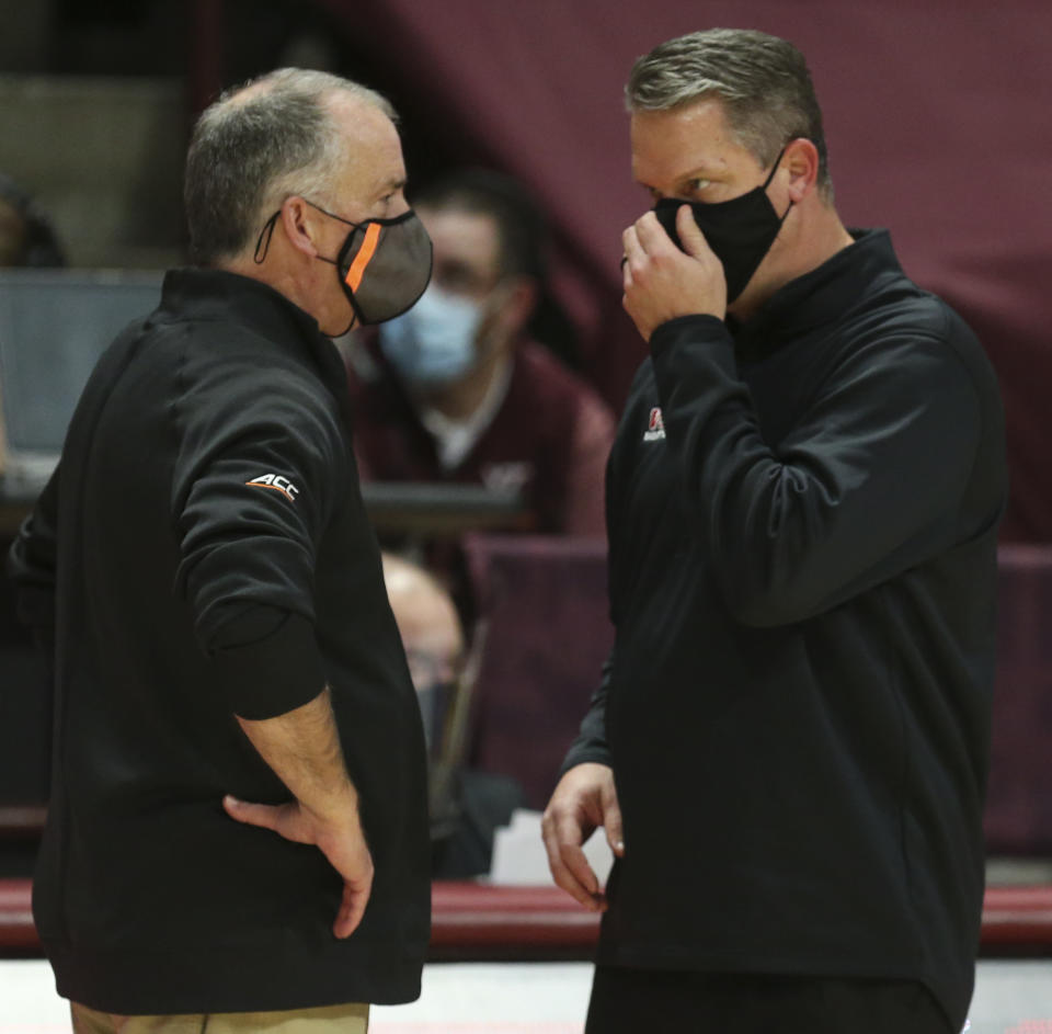 Virginia Tech head coach Mike Young, left, and VMI head coach Dan Earl talk at the conclusion of an NCAA college basketball game, Thursday, Dec. 3, 2020 in Blacksburg, Va. (Matt Gentry/The Roanoke Times via AP, Pool)