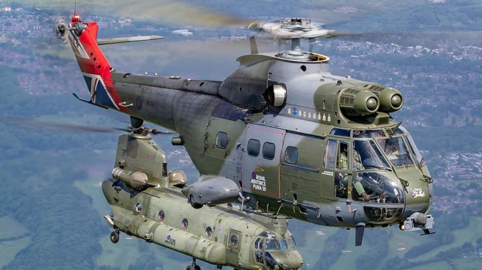 A RAF Puma helicopter from 230 Squadron flies in formation with a Chinook (27(R) Squadron) over RAF Cosford. <em>UK Ministry of Defense</em>