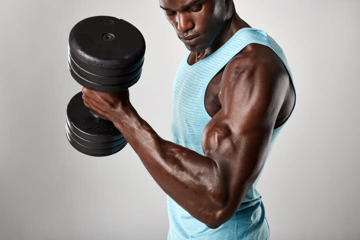 Man with big muscles lifting weights