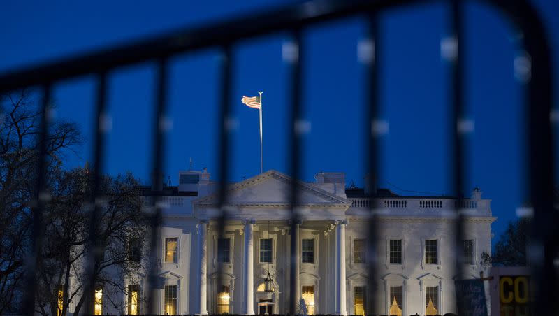 The White House is seen through a security fence, before sunrise, in Washington on March 23, 2019.