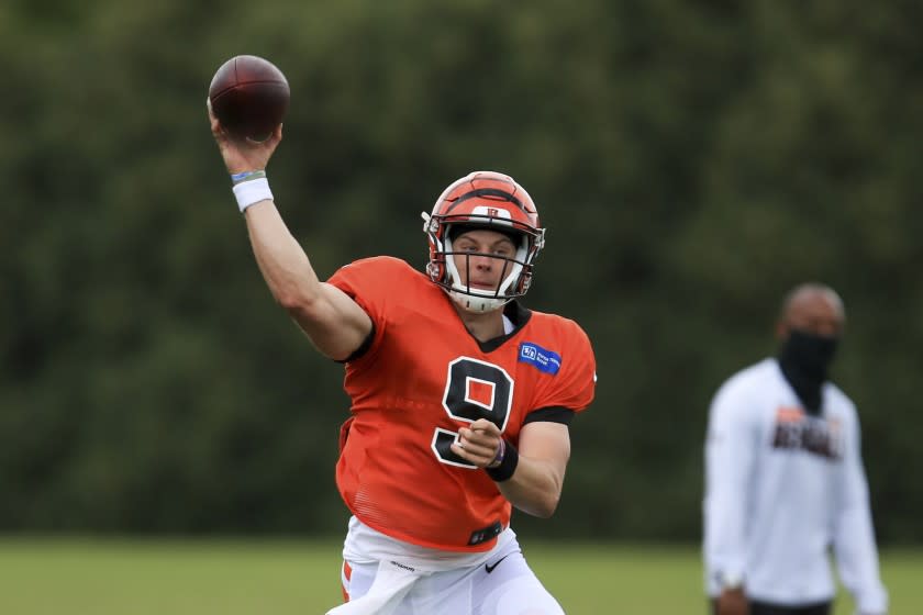 Cincinnati Bengals' Joe Burrow (9) scrambles as he throws a pass during an NFL football camp practice in Cincinnati, Tuesday, Aug. 18, 2020. (AP Photo/Aaron Doster)