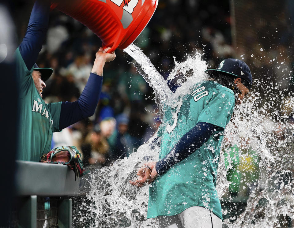 Seattle Mariners catcher Tom Murphy douses shortstop J.P. Crawford as they celebrate a 7-5 win over the Houston Astros in a baseball game Saturday, May 6, 2023, in Seattle. (AP Photo/Lindsey Wasson)