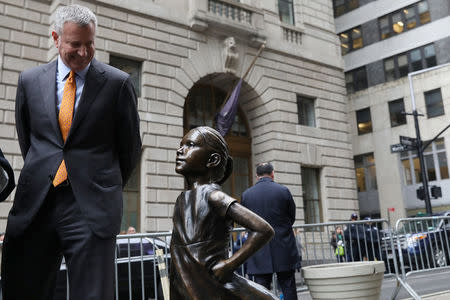 New York City Mayor Bill de Blasio smiles at the 'Fearless Girl" statue during a press conference in New York, U.S., March 27, 2017. REUTERS/Shannon Stapleton
