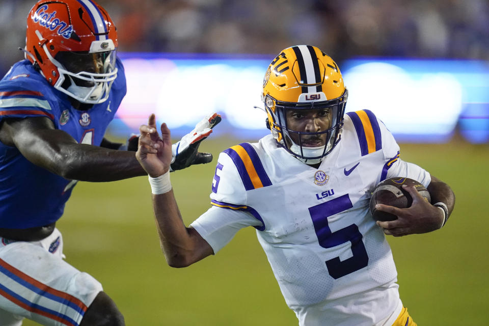 LSU quarterback Jayden Daniels (5) slips by Florida linebacker Brenton Cox Jr. for a 9-yard touchdown run during the second half of an NCAA college football game, Saturday, Oct. 15, 2022, in Gainesville, Fla. (AP Photo/John Raoux)