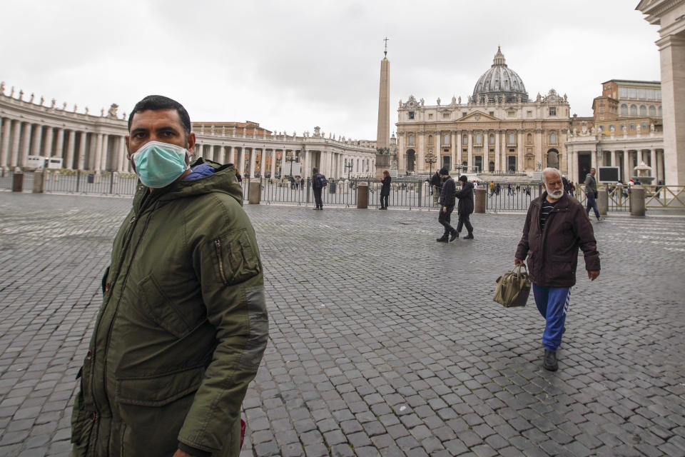 A man wearing a mask walks in St. Peter's Square at the Vatican, Friday, March 6, 2020. A Vatican spokesman has confirmed the first case of coronavirus at the city-state. Vatican spokesman Matteo Bruni said Friday that non-emergency medical services at the Vatican have been closed so they can be sanitized following the positive test on Thursday. (AP Photo/Andrew Medichini)