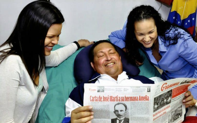 Venezuelas' VTV shows President Hugo Chavez, surrounded by his daughters and holding an issue of Granma, Cuba's official newspaper, at hospital in Havana on February 15, 2013
