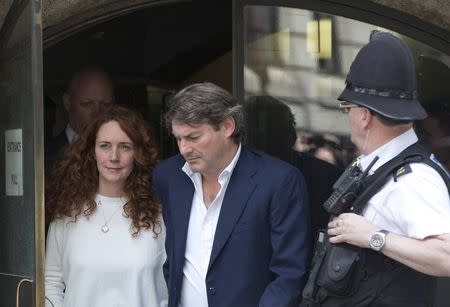 Former News International chief executive Rebekah Brooks (L) and her husband Charlie (R) leave the Old Bailey courthouse in London June 24, 2014.REUTERS/Neil Hall