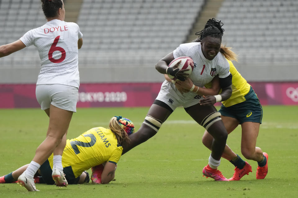 Cheta Emba of the United States, second right, comes under pressure from Australia's Charlotte Caslick, right, and Australia's Sharni Williams, in their women's rugby sevens match at the 2020 Summer Olympics, Friday, July 30, 2021 in Tokyo, Japan. (AP Photo/Shuji Kajiyama)