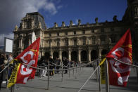 Visitors wait in line as workers of the culture industry demonstrate outside the Louvre museum Monday, March 27, 2023 in Paris. President Emmanuel Macron inflamed public anger by sending his already unpopular plan to raise the retirement age by two years, from 62 to 64, through parliament without a vote. (AP Photo/Christophe Ena)