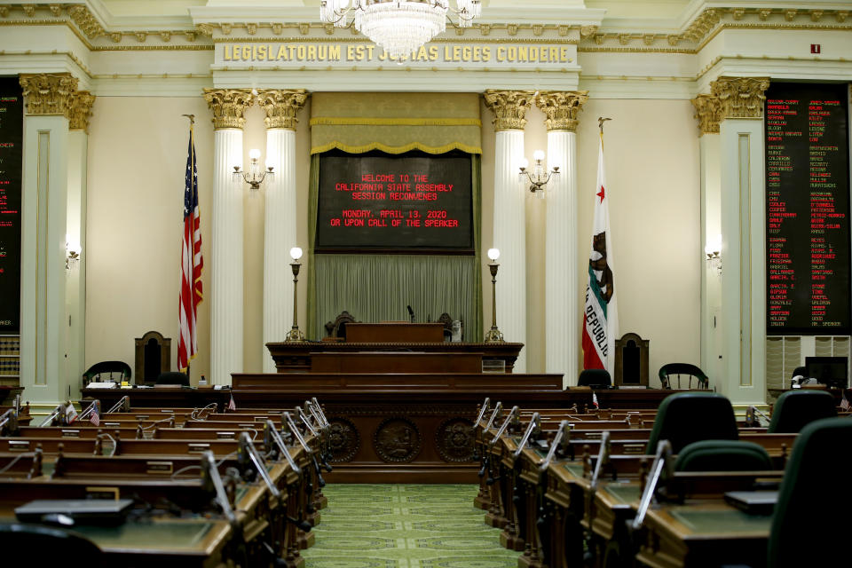 The state Assembly Chambers sits empty at the Capitol in Sacramento, Calif., Wednesday, March 18, 2020. In a precautionary effort to deal with the coronavirus, the Capitol and Legislative Office Building were closed to the public with only essential state workers and legislative employees allowed in until further notice, based on a "stay at home" directive issued by Sacramento County. (AP Photo/Rich Pedroncelli)