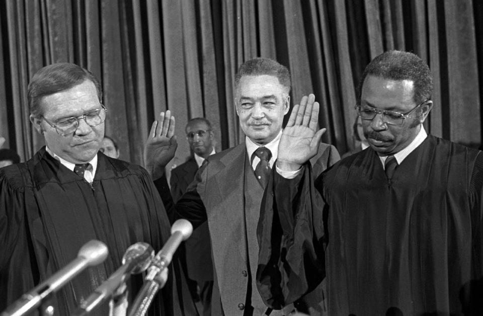 Michigan Supreme Court Judge John Swainson, left, and Judge Damon Keith, right, administer the oath of office to newly elected Detroit Mayor Coleman A. Young during the 1974 inauguration ceremony.
