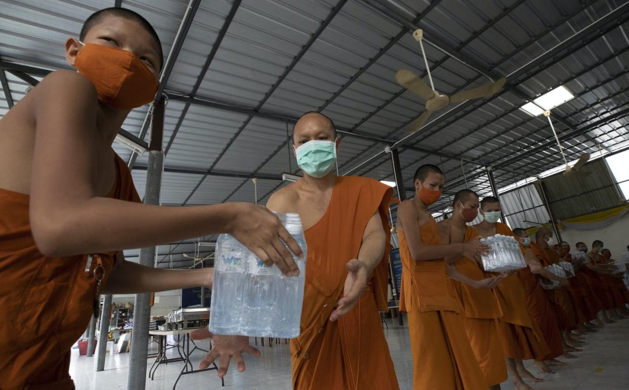 <span class="caption">Buddhist monks pass packs of water after their devotees donated water to a temple in Bangkok.</span> <span class="attribution"><a class="link " href="http://www.apimages.com/search?query=buddhist+monks+donating+thai&entitysearch=&st=kw&ss=10&allFilters=&toItem=15&orderBy=Newest" rel="nofollow noopener" target="_blank" data-ylk="slk:AP Photo/Sakchai Lalit;elm:context_link;itc:0;sec:content-canvas">AP Photo/Sakchai Lalit</a></span>