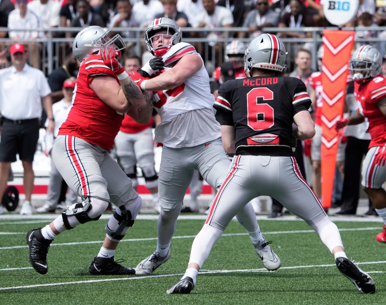 April 15, 2023; Columbus, Ohio, USA;  
Offensive lineman Matthew Jones (55) and defensive end Jack Sawyer (33) mix it up as quarterback Kyle McCord (6) looks for an open man during the first quarter of the Ohio State spring football game Saturday at Ohio Stadium.
Mandatory Credit: Barbara J. Perenic/Columbus Dispatch