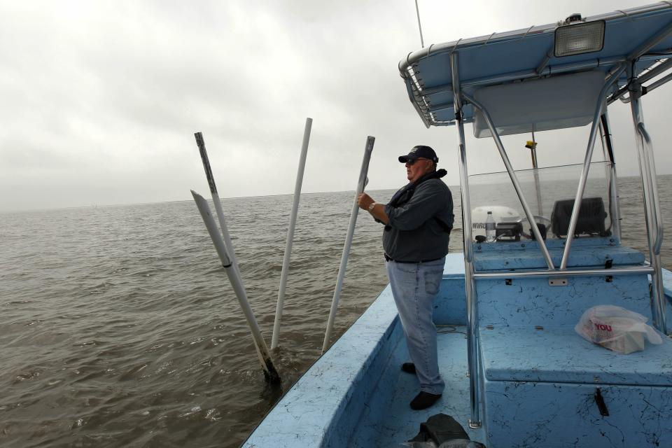 FILE - In an April 8, 2011 file photo, Dave Cvitanovich, an oysterman who has worked the waters of Louisiana his whole life, works on his boat at one of his oyster beds in Bay Jimmy in Plaquemine's Parish, La. His oysters were damaged by the fresh water diversion program by the state of Louisiana. It will be months before state officials know whether losses from floods and spillway openings qualify Louisiana as a fisheries disaster. Department of Wildlife and Fisheries officials say floods began around November 2018, and a full 12 months' data is needed to compare to averages for the previous 5 years. The governors of Louisiana, Mississippi and Alabama asked months ago for US Commerce Secretary Wilbur Ross to declare a fisheries disaster, making federal grants available to affected people. (AP Photo/Gerald Herbert, File)