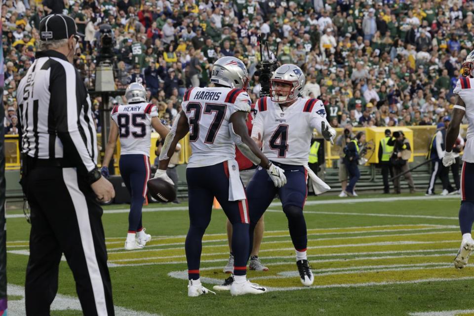 New England Patriots running back Damien Harris celebrates his touchdown with quarterback Bailey Zappe.