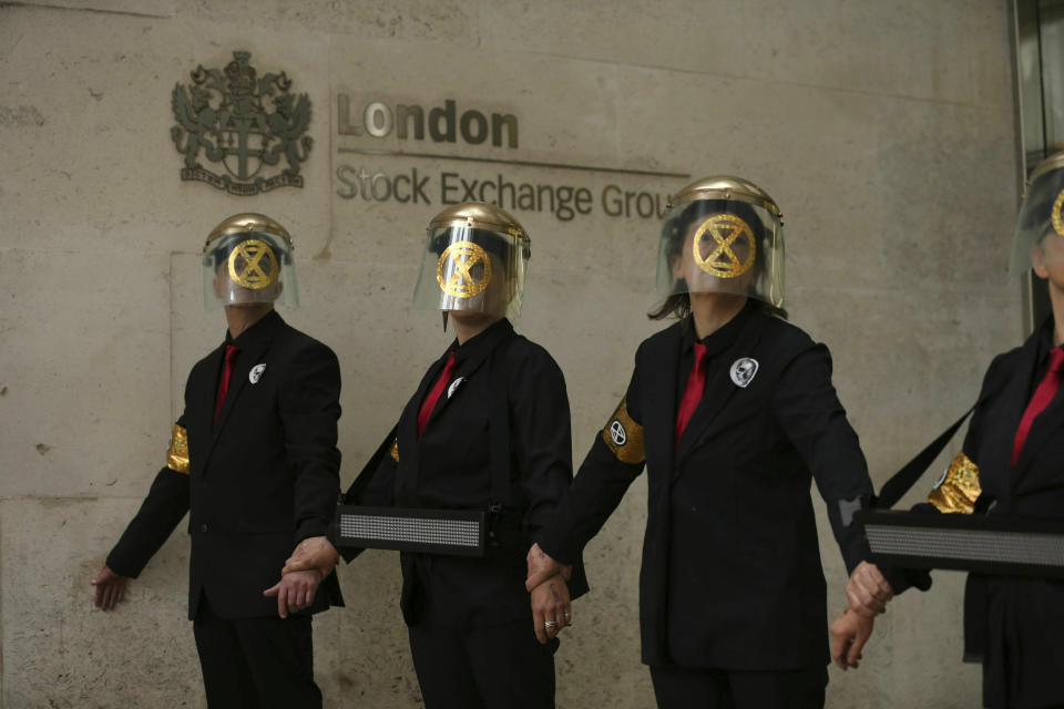 Extinction Rebellion climate protesters form a line after glueing themselves to the entrances of the London Stock Exchange in the City of London, Thursday April 25, 2019. (Isabel Infantes/PA via AP)