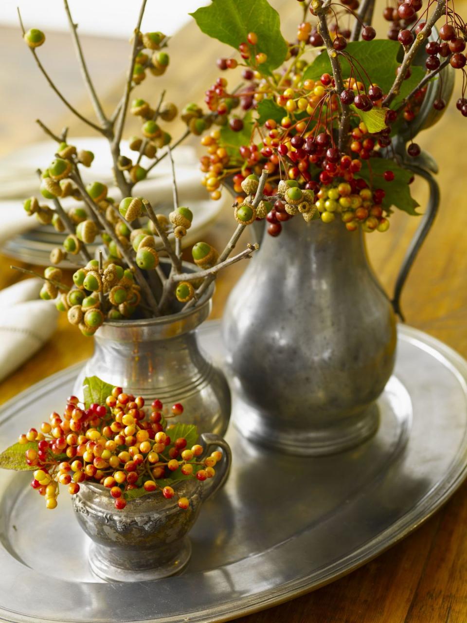 <p>Combine old and new with this Thanksgiving-ready centerpiece. Fill pewter or china pitchers you have stashed away in the attic with foliage from your backyard. </p>