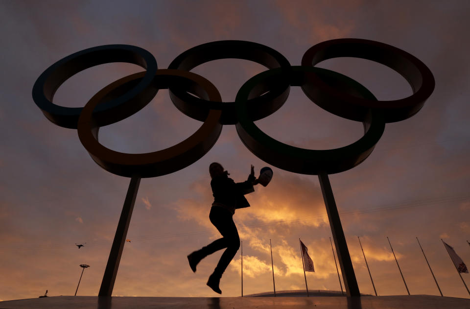 AP10thingsToSee - A woman poses for a photo with the Olympic rings in Olympic Park as preparations continue for the 2014 Winter Olympics in Sochi, Russia on Wednesday, Feb. 5, 2014. (AP Photo/Charlie Riedel, File)