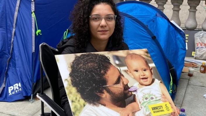 Sanaa Seif holds a photo of her brother Alaa Abdel Fattah and his son at a sit-in protest outside the Foreign, Commonwealth and Development Office in London, UK (1 November 2022)