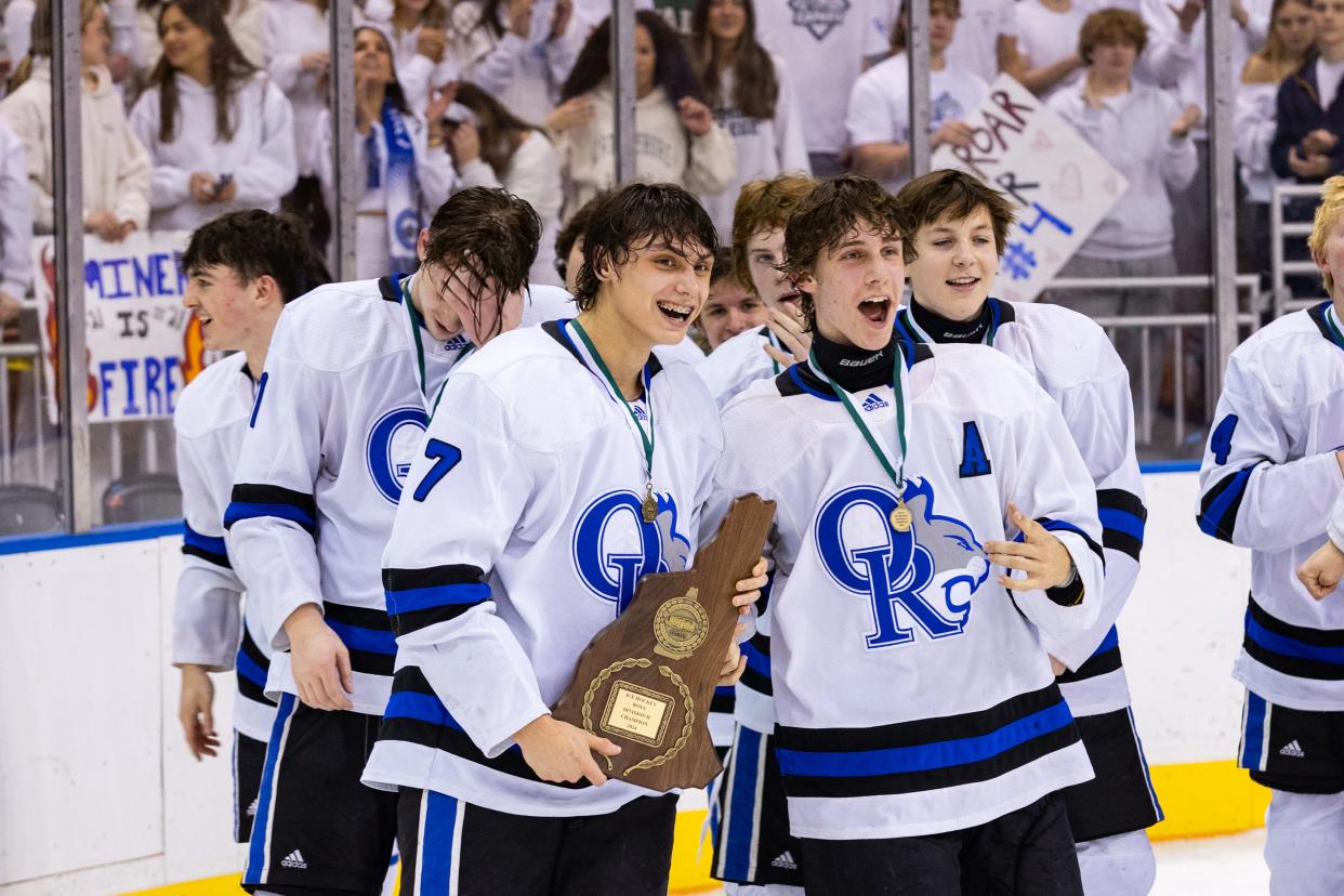 Oyster River's Talon Beyer (7) and Sawyer Levesque (13) celebrate with teammates following Saturday's 3-0 win over Spaulding in the Division II state championship game at Southern New Hampshire University Arena in Manchester.