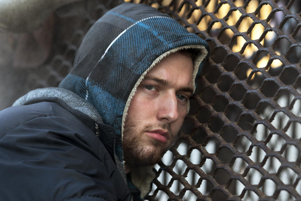 Nicholas Simmons, 20, of Greece, N.Y., warms himself on a steam grate with three homeless men by the Federal Trade Commission, just blocks from the Capitol, during frigid temperatures in Washington, Saturday, Jan. 4, 2014. On New Year’s Day, Simmons disappeared from his parents’ house in a small upstate New York town, leaving behind his wallet, cellphone and everything else. Four days later, an Associated Press photographer, looking for a way to illustrate unusually cold weather, took his picture as he warmed himself on a steam grate a few blocks from the U.S. Capitol. His parents Paul and Michelle Simmons saw the photograph in USA Today Sunday morning after it was brought to their attention through a Facebook page set up to help find their son, according to police and family friends, and were able to report his location to D.C. police who transported him to a hospital where he was reunited with his father and brother who drove all day to find him. (AP Photo/Jacquelyn Martin)