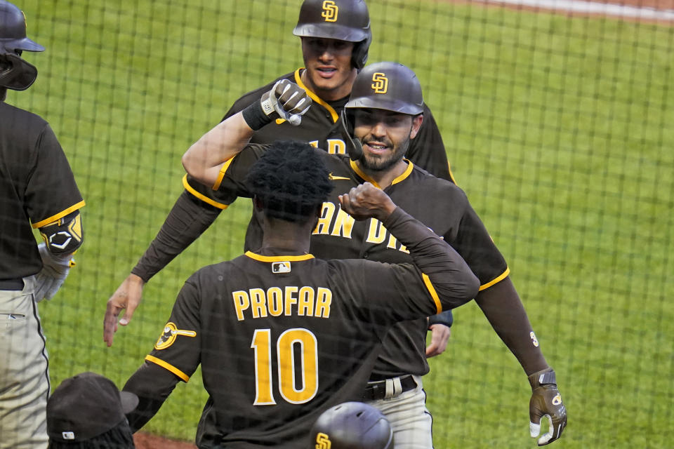 San Diego Padres' Eric Hosmer, center, is congratulated as he returns to the dugout after hitting a three-run home run off Pittsburgh Pirates starting pitcher JT Brubaker during the fourth inning of a baseball game in Pittsburgh, Saturday, April 30, 2022. (AP Photo/Gene J. Puskar)