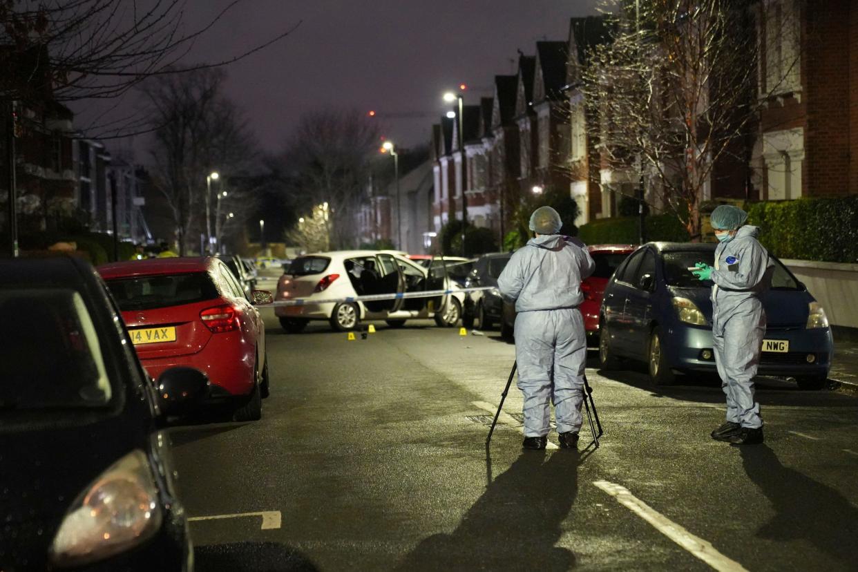 Police inspect the scene of an incident near Clapham Common, south London, after a suspected corrosive substance was thrown at a woman and her two young children Wednesday Jan. 31, 2024. British police said Wednesday they are hunting for a suspect after several people were injured with a corrosive substance in London.