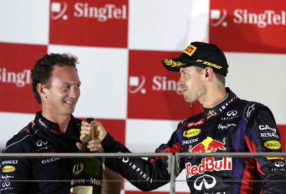 Red Bull team principal Christian Horner (L) celebrates on the podium with Red Bull Formula One driver Sebastian Vettel of Germany after Vettel won the Singapore F1 Grand Prix at the Marina Bay street circuit in Singapore September 22, 2013. Vettel cruised to a third straight Singapore Grand Prix victory on Sunday and moved closer to a fourth consecutive Formula One world title with a dominant drive under the floodlights at the Marina Bay Street Circuit. REUTERS/Pablo Sanchez (SINGAPORE - Tags: SPORT MOTORSPORT F1)