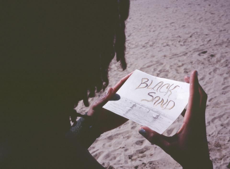 Gage Crismond looks at a photograph created by Chanae Owens of the Black Sand Paddle out.