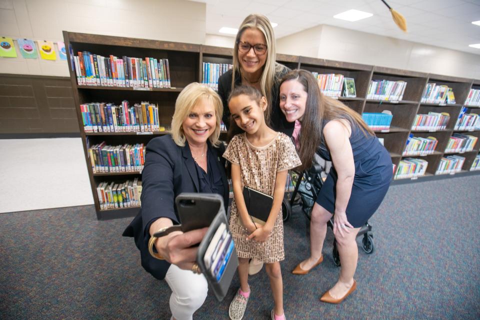From left, Marion County Commission Chairwoman Michelle Stone, School Board member Sarah James and Ocala City Council President Pro-Tem Kristen Dreyer grab a selfie on Friday with Shayla Reeves, 9, at East Marion Elementary School in Silver Springs.