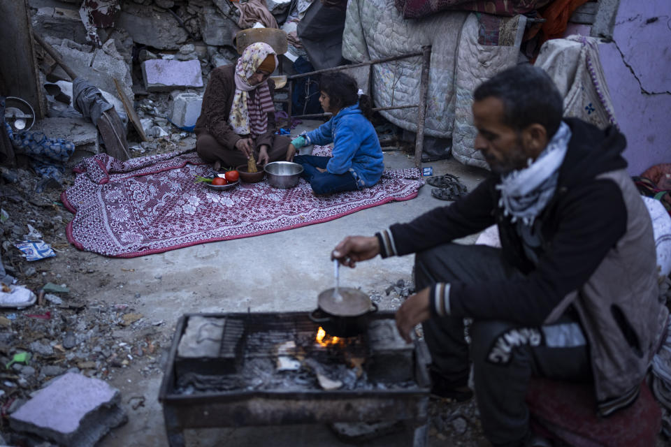 Members of the Al-Rabaya family break their fast during the Muslim holy month of Ramadan outside their destroyed home by the Israeli airstrikes in Rafah, Gaza Strip, Monday, March 18, 2024. (AP Photo/Fatima Shbair)