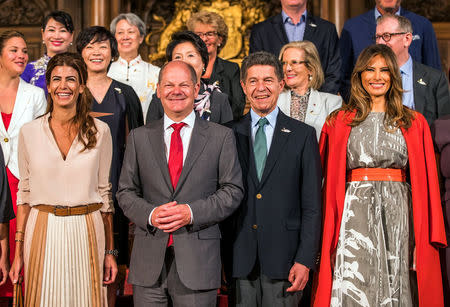 Hamburg mayor Olaf Scholz and husband of German chancellor Joachim Sauer pose with Argentina President's wife Juliana Awada (L) and U.S. First Lady Melania Trump for a group picture at the townhall during the G20 leaders summit in Hamburg, Germany July 8, 2017. REUTERS/Jens Buettner, Pool