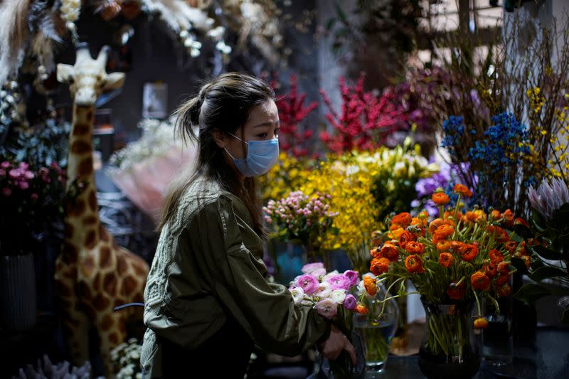 Florist Wang Haiyan, 41, works among flowers inside her shop as the country is hit by an outbreak of the new coronavirus, in Shanghai