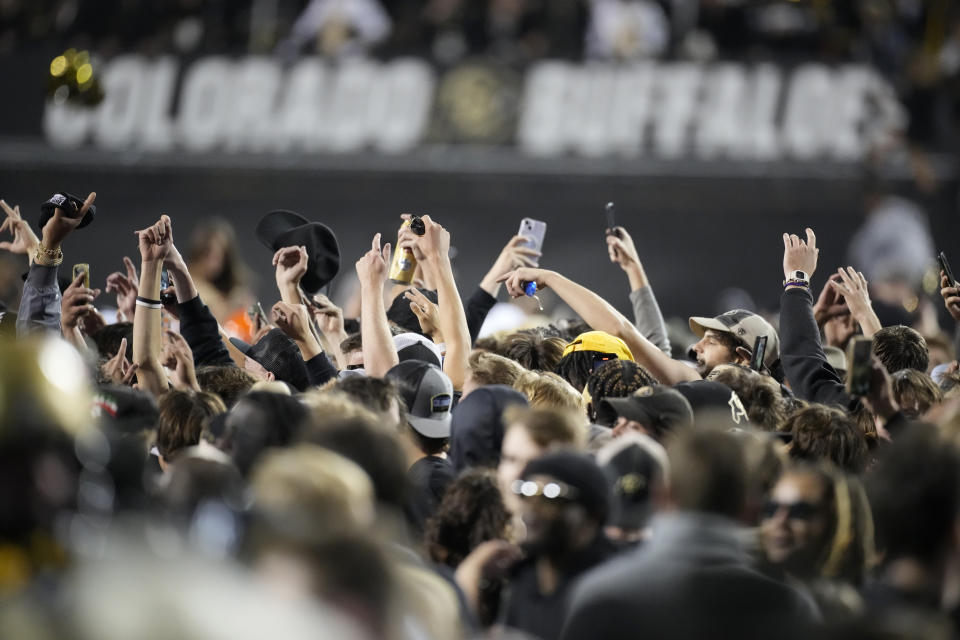 Fans rush the field to celebrate after Colorado defeated Colorado State in an NCAA college football game Saturday, Sept. 16, 2023, in Boulder, Colo. (AP Photo/David Zalubowski)