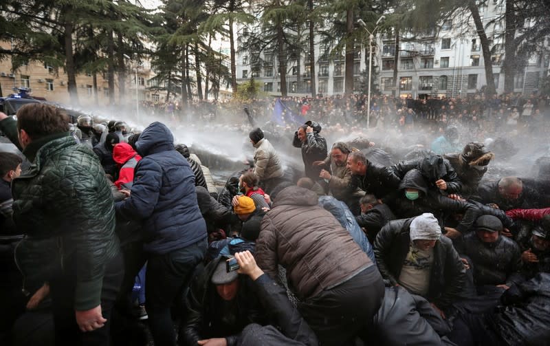 Riot police use water canon to disperse demonstrators during a protest against the government and to demand an early parliamentary election in Tbilisi