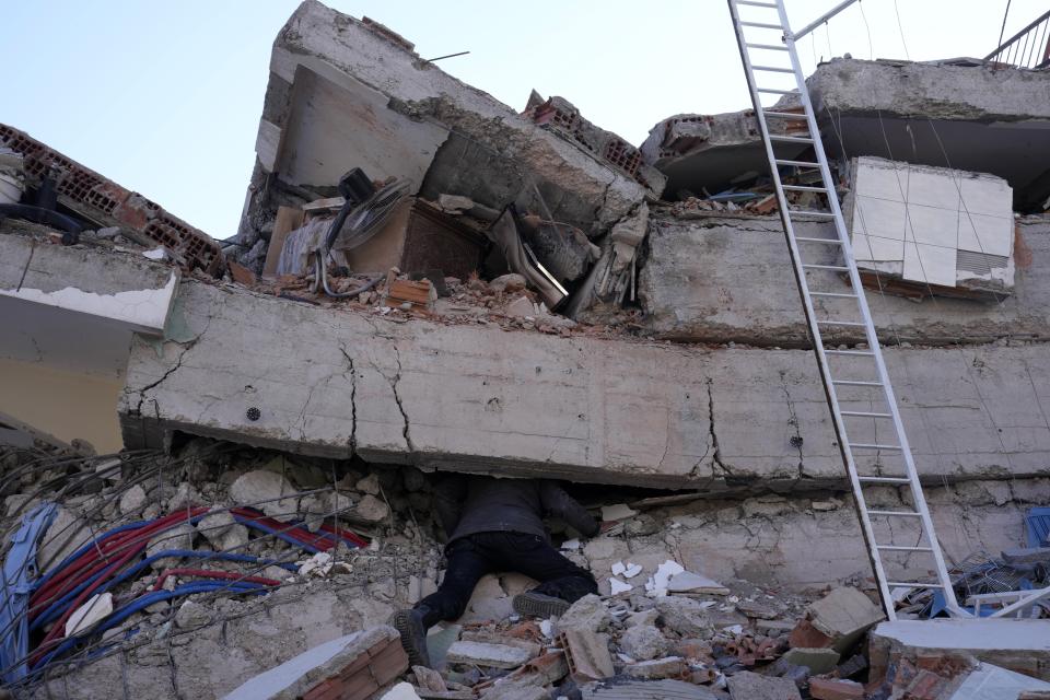 A man searches for survivors at a destroyed building in Kahramanmaras, southern Turkey, Wednesday, Feb. 8, 2023. With the hope of finding survivors fading, stretched rescue teams in Turkey and Syria searched Wednesday for signs of life in the rubble of thousands of buildings toppled by a catastrophic earthquake. (AP Photo/Hussein Malla)