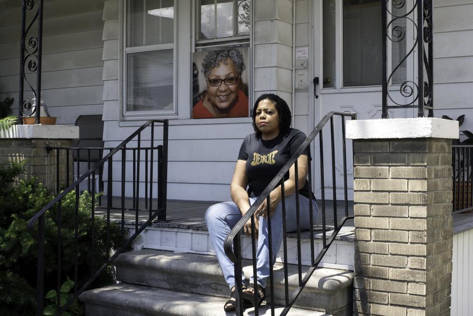 Biba Adams on the porch of her Hamtramck, Michigan, home with a picture of her mother — who succumbed to complications from Covid-19 — on June 19th, 2020. - Credit: Rachel Elise Thomas